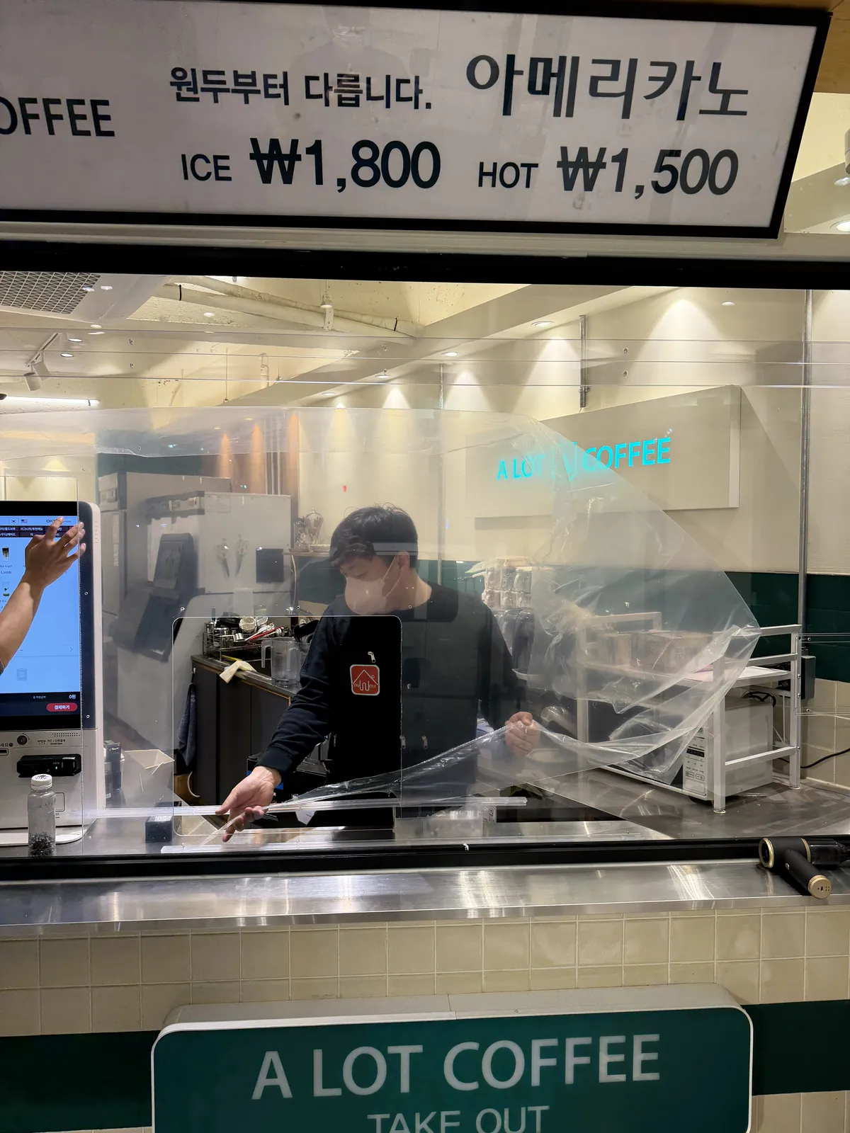 어랏커피 경북대북문점 가림막의 보호 비닐을 제거하는 시공 마무리 장면